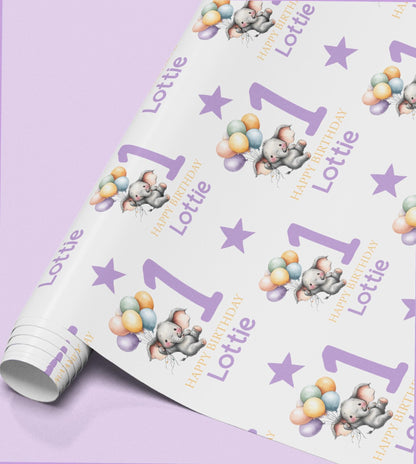 Roll of personalised purple elephant birthday wrapping paper printed with the name Lottie and a balloon design.