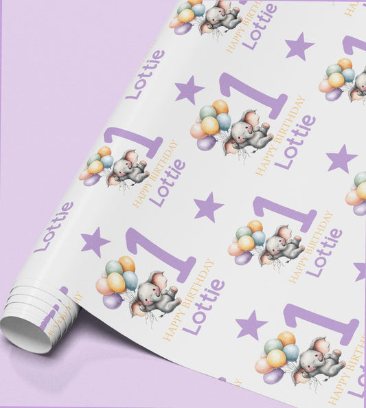 a roll of wrapping paper with a repeating pattern of elephants holding balloons and the name "Lottie" written on it.