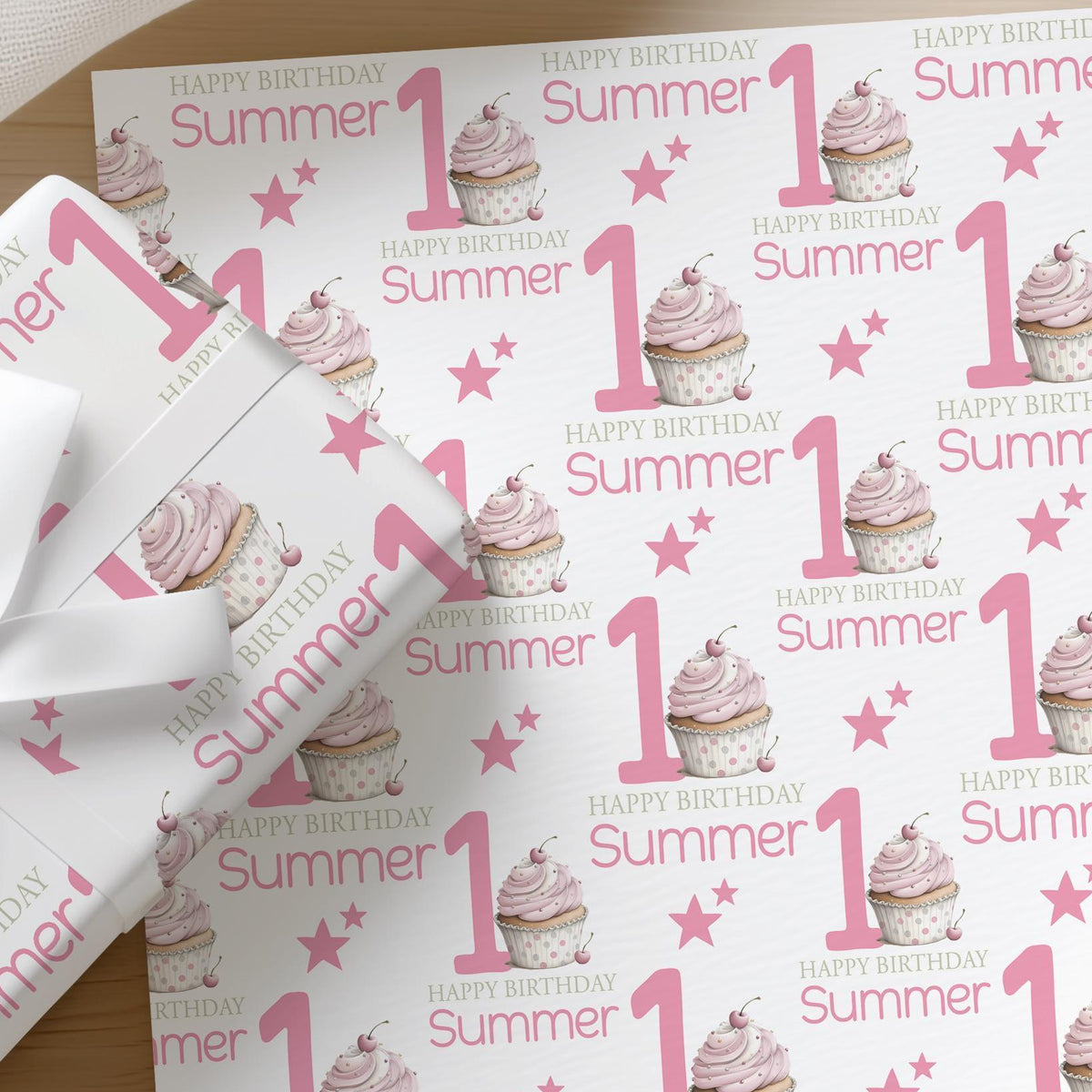 Roll of personalised pink cupcake wrapping paper with an example name printed on the design