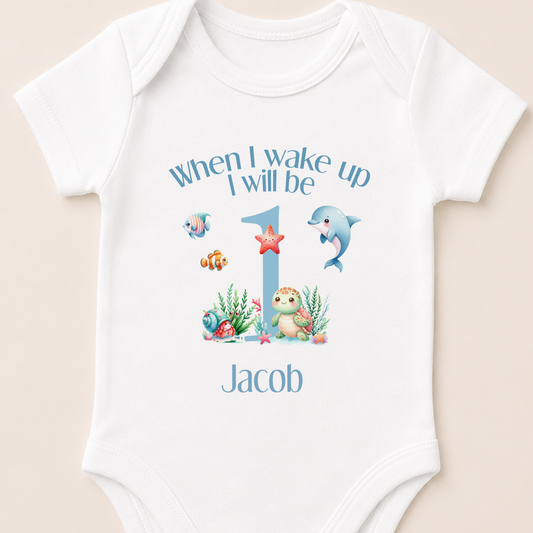 Personalised vest printed with 'When I wake up I will be...' and your child's name, alongside a dolphin, starfish and other under the sea characters.