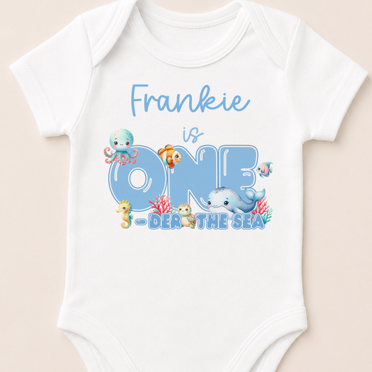 Personalised Under the Sea first birthday onesie printed with your child's name and colourful sea creature design.