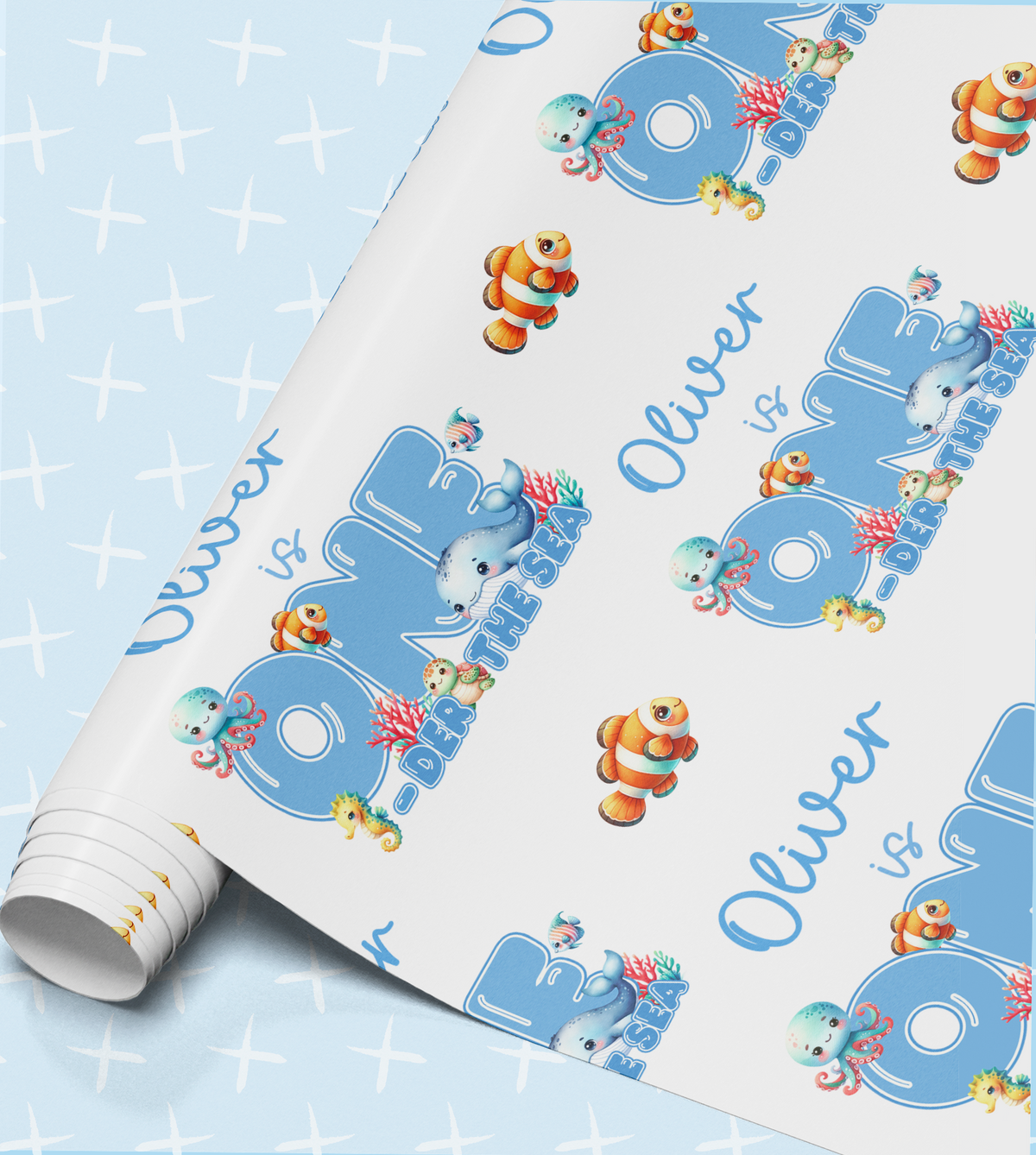 The image is a roll of wrapping paper with a repeating pattern of cartoon fish and the name "Oliver" written on it.