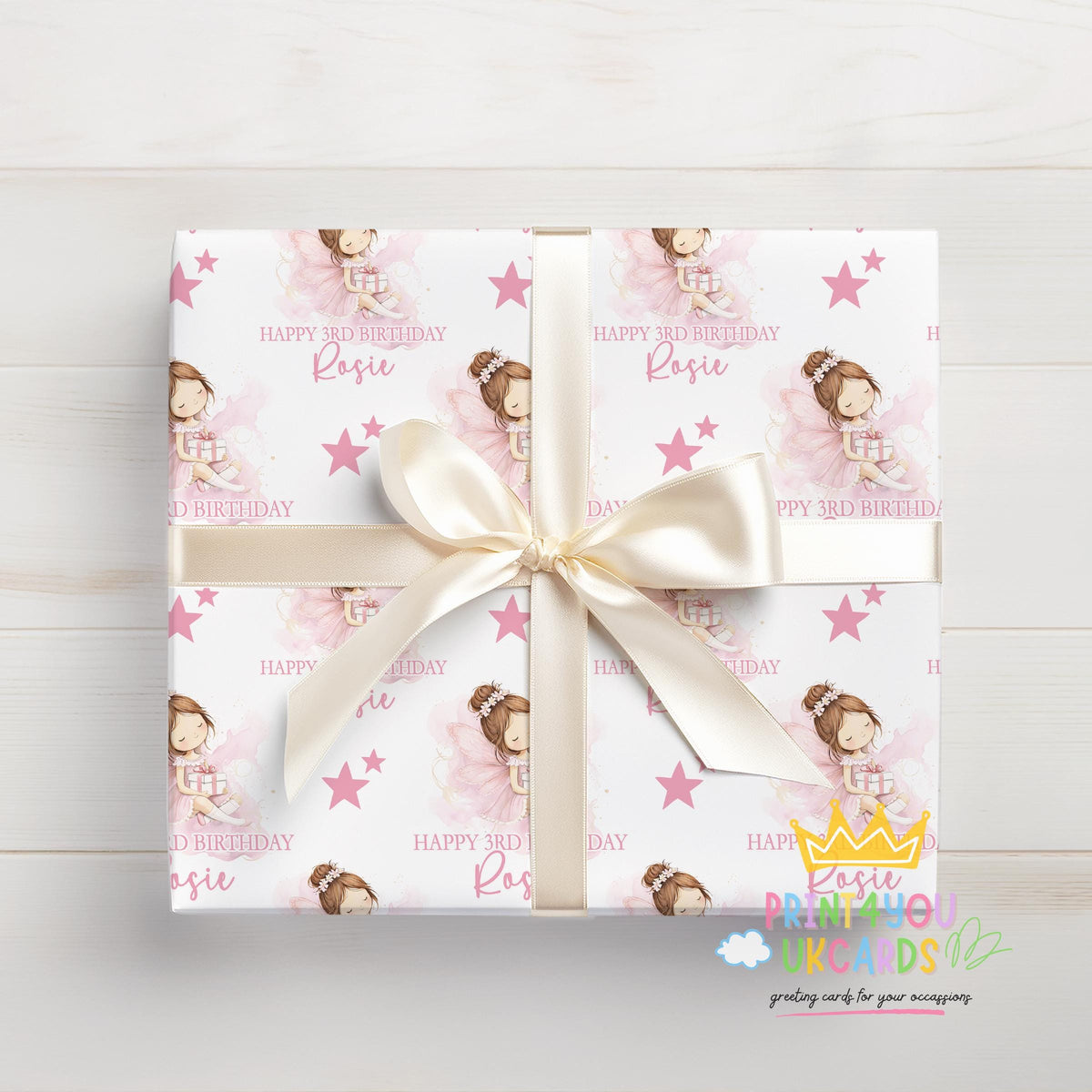 Personalised pink fairy birthday wrapping paper wrapped around a gift