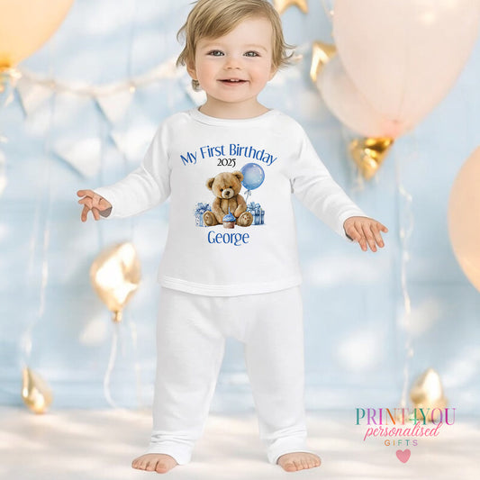 Blue teddy bear personalised first birthday pyjamas for 6-12 months, printed with baby's name on soft white cotton.