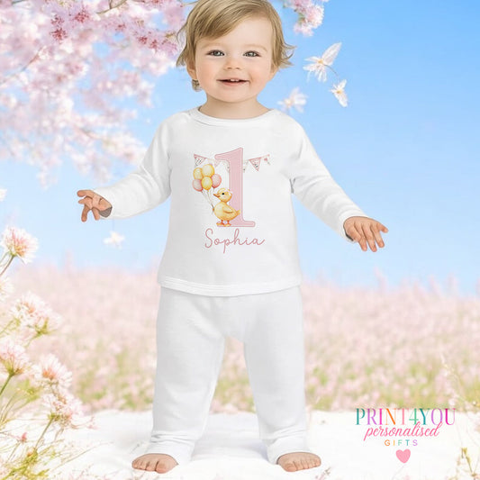 Pink duck personalised first birthday pyjamas for 6-12 months, printed with baby's name on soft white cotton.