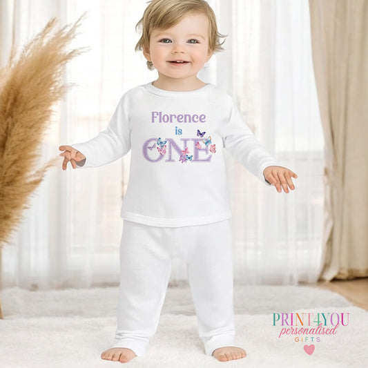 Purple butterfly personalised first birthday pyjamas for 6-12 months, printed with baby's name on soft white cotton.