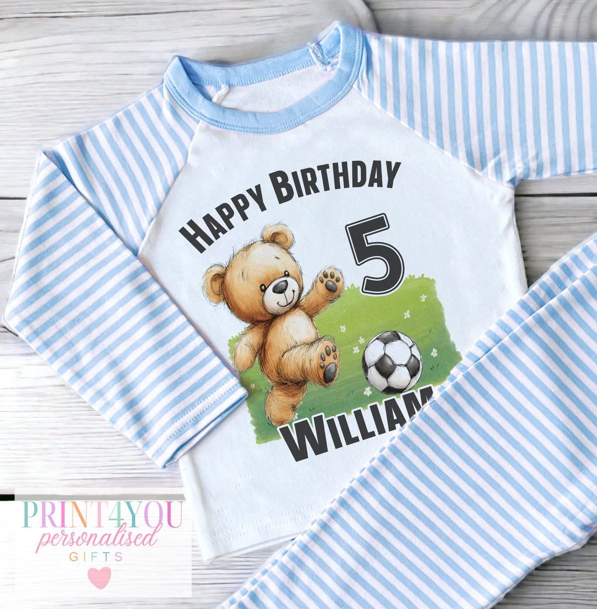 Personalised blue and white striped boys' pyjamas with a teddy bear playing football design, personalised with child's name