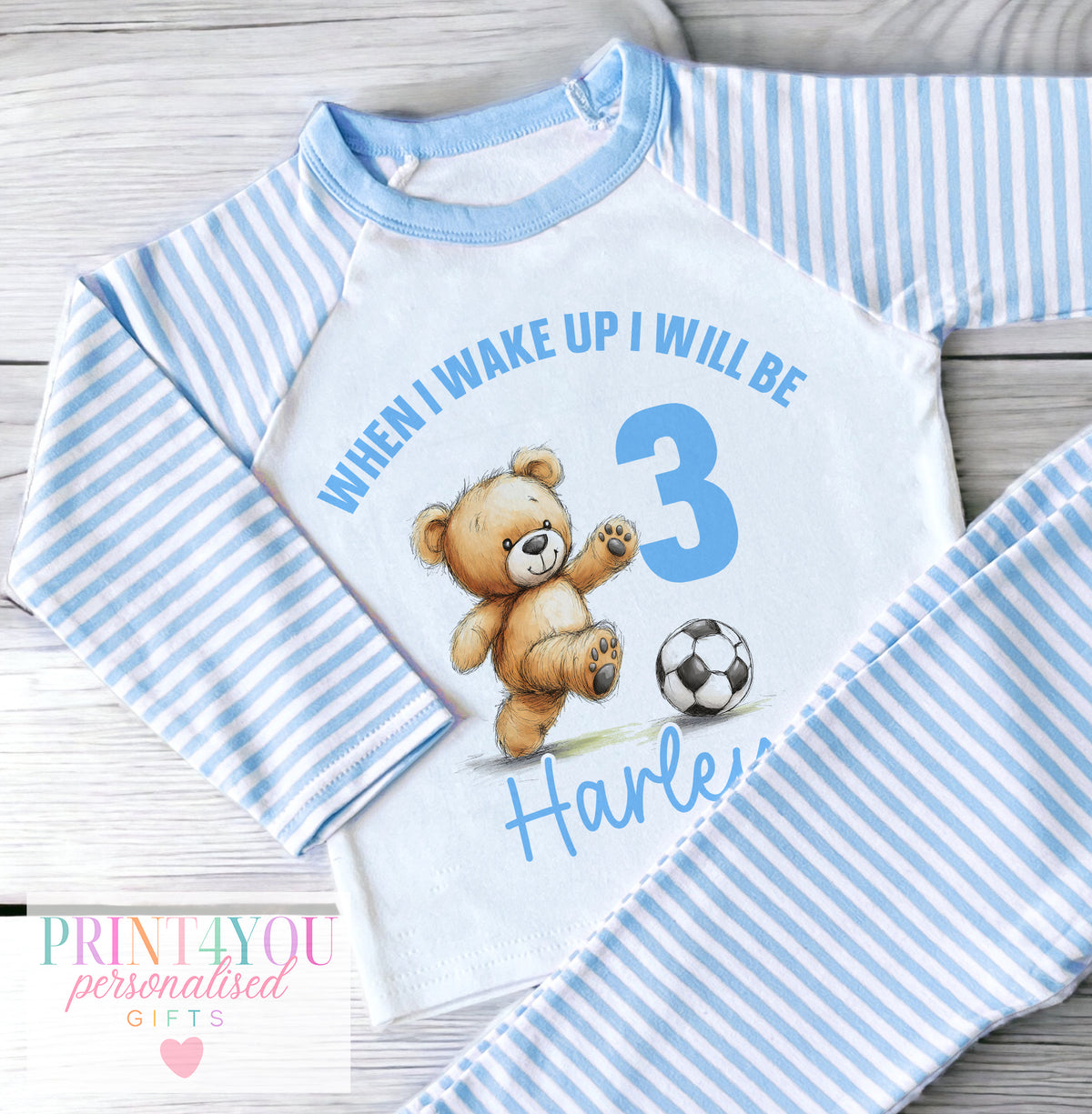 Personalised blue and white striped boys' pyjamas with a football-playing bear and When I Wake Up message, personalised with child's name