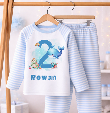 Personalised ocean theme blue stripe pyjamas for a boy's 1st birthday, laid flat