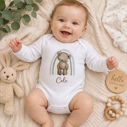 Personalised teddy bear baby vest styled with soft nursery essentials.