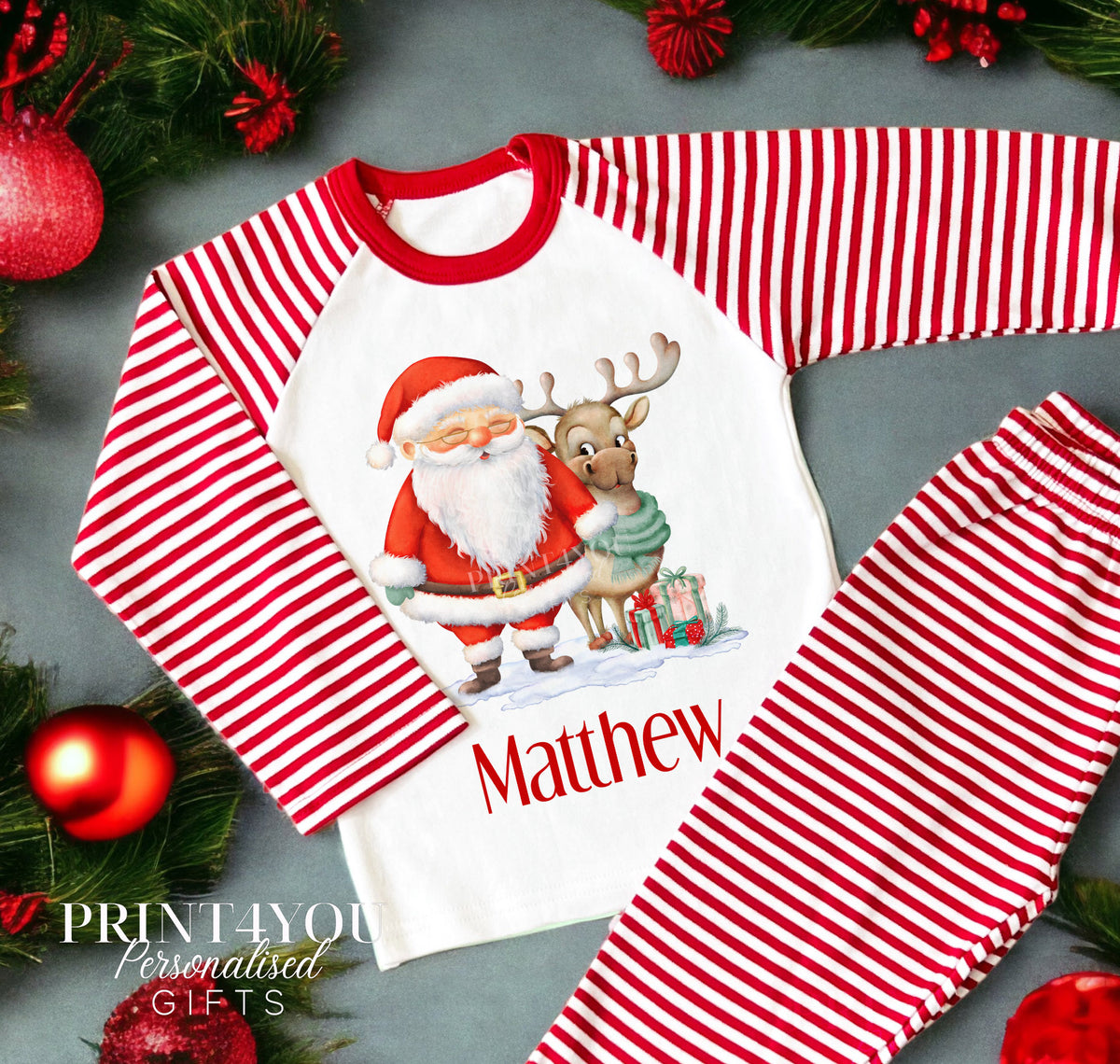Personalised red and white striped Christmas Eve pyjamas for kids with Santa and Reindeer design and custom name printed on the front