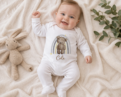 Personalised teddy bear baby vest, custom printed with the baby's name, shown on a soft blanket.