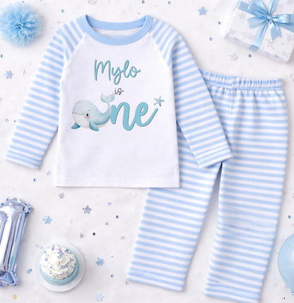 Close-up of the whale motif and personalised name printed on the blue stripe pyjama top