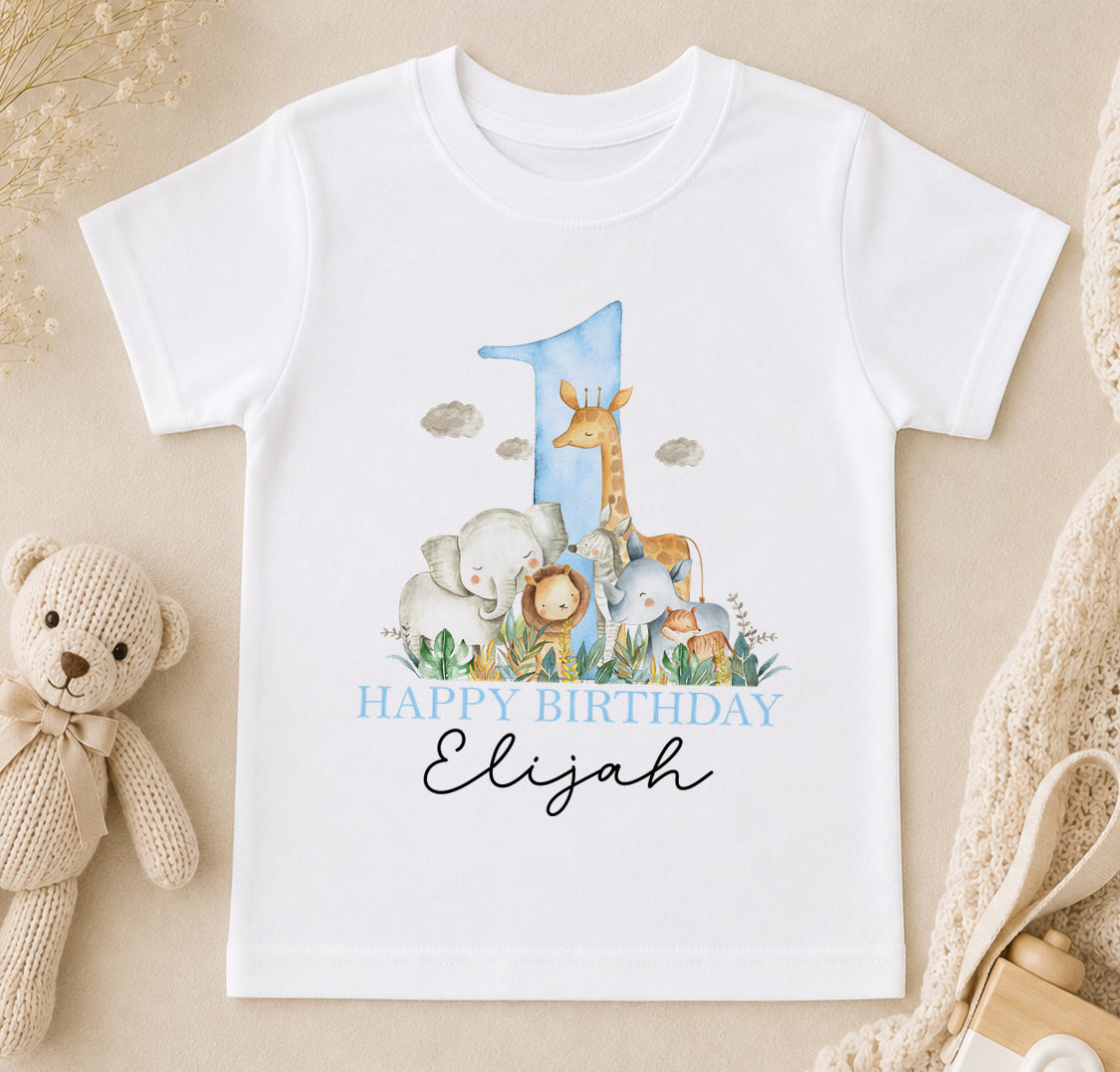 A white t-shirt with a printed image of a giraffe, elephants, and a blue number one, along with the text "Happy Birthday Elijah".