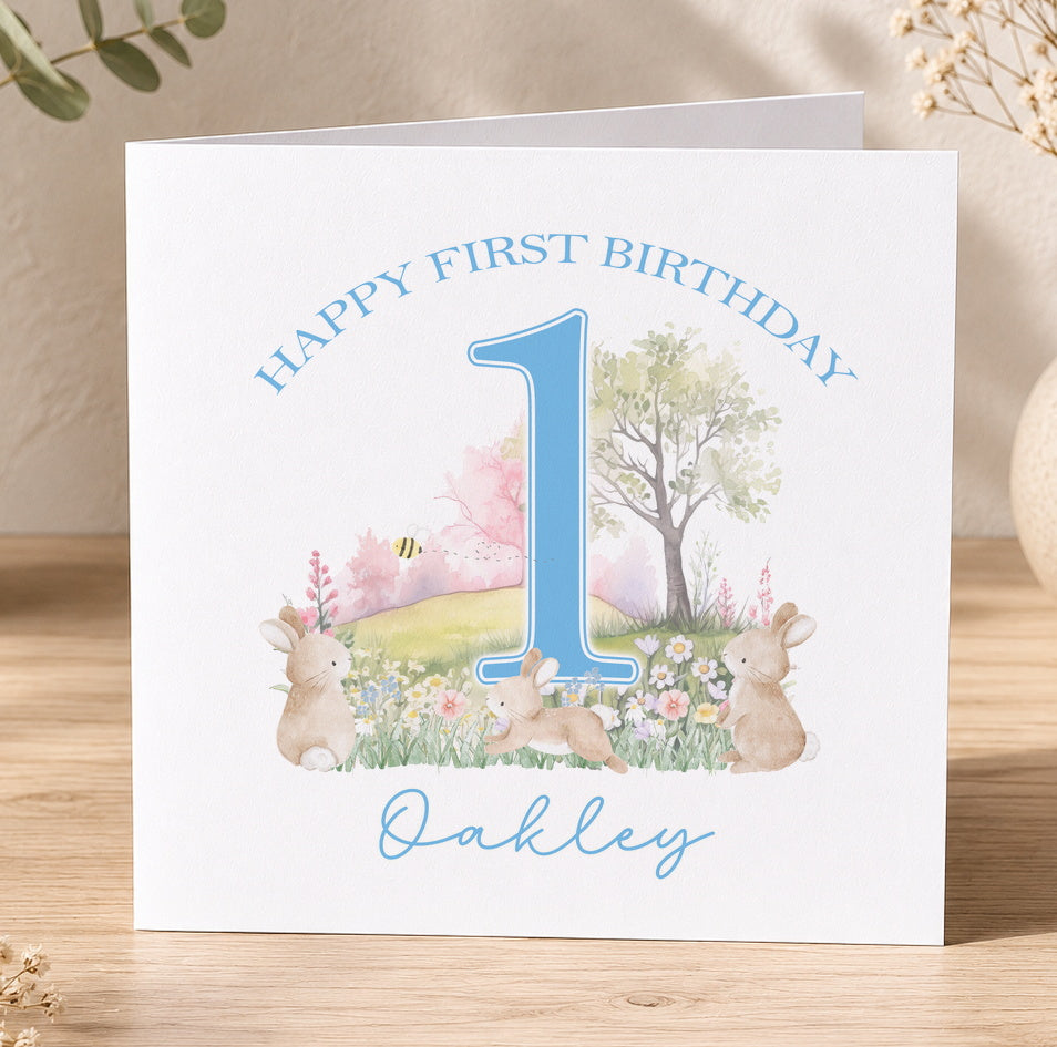 White square first birthday card featuring a blue number 1 and a smiling bunny illustration, personalised for a baby boy