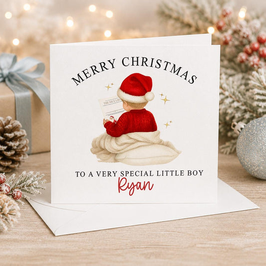 Personalised Christmas card, white 6x6 inch square card printed with a sleeping baby in a red Santa hat, Merry Christmas and a name