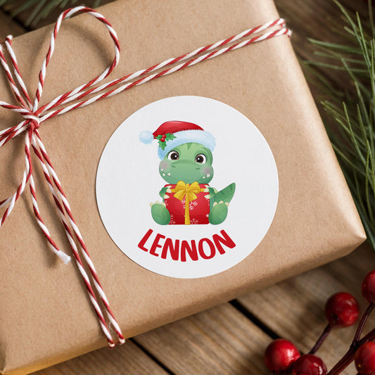 Personalised Santa dinosaur Christmas sticker with a child's name in red capitals on a wrapped gift