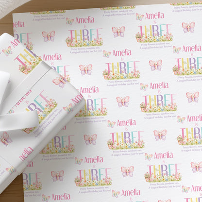 Roll of personalised butterfly garden birthday wrapping paper printed with a name and age