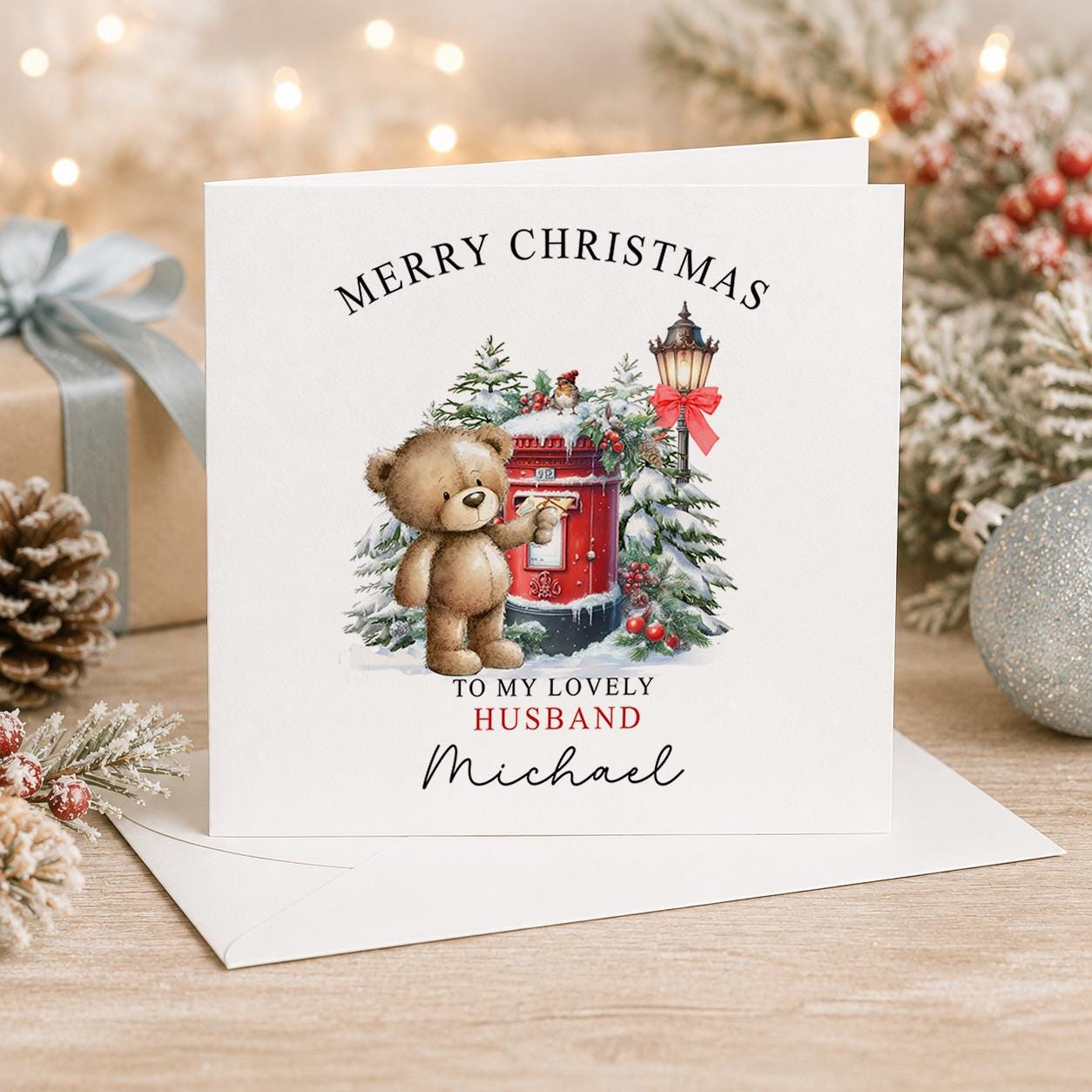 Personalised teddy bear Christmas card, white 6x6 inch square card printed with a teddy bear beside a red post box and a name
