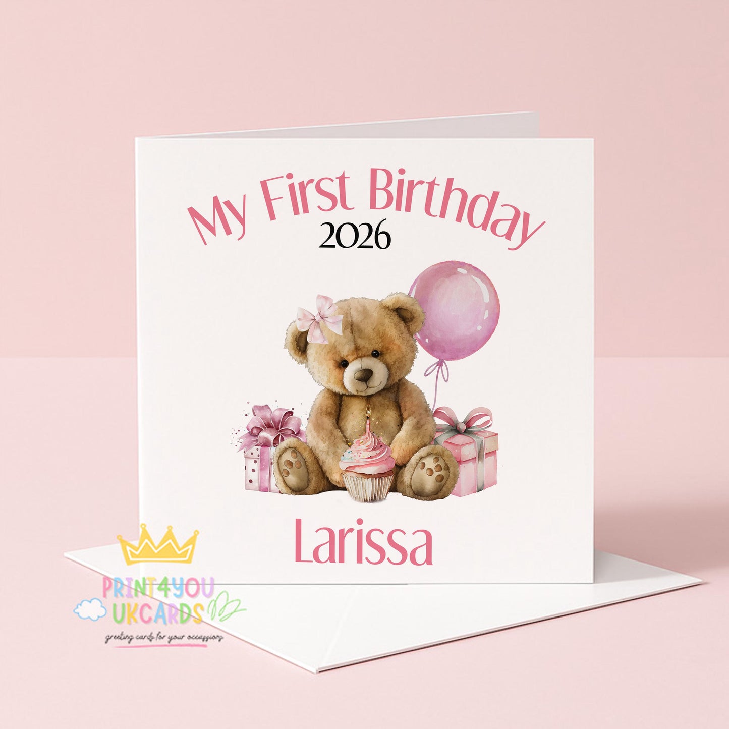 Square pink first birthday card featuring a teddy bear design, shown personalised with a name and year