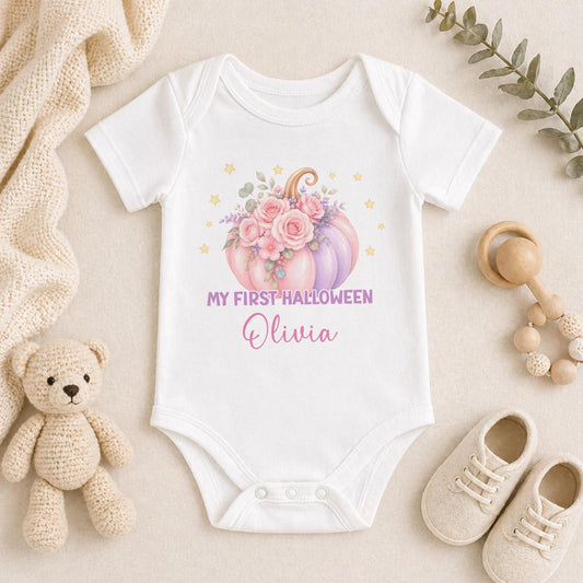 Personalised baby’s first Halloween white vest featuring a pastel pink and purple floral pumpkin, golden stars and baby’s name.