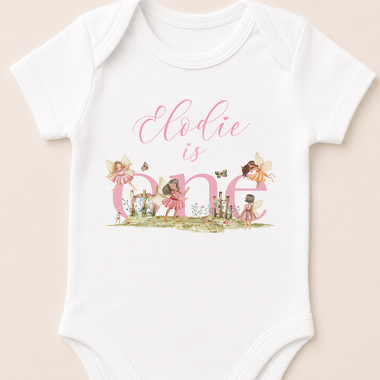 Personalised pink fairytale fairies vest, printed with your baby's name and fairy illustrations on soft white cotton.