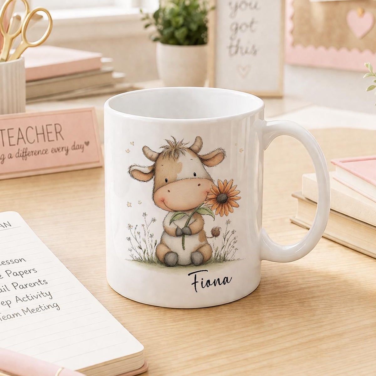 White ceramic mug printed with a cow and floral design, personalised with a name