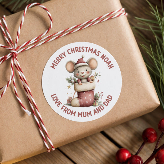 Personalised Christmas mouse sticker with custom name on a wrapped gift box with festive berries and decorations