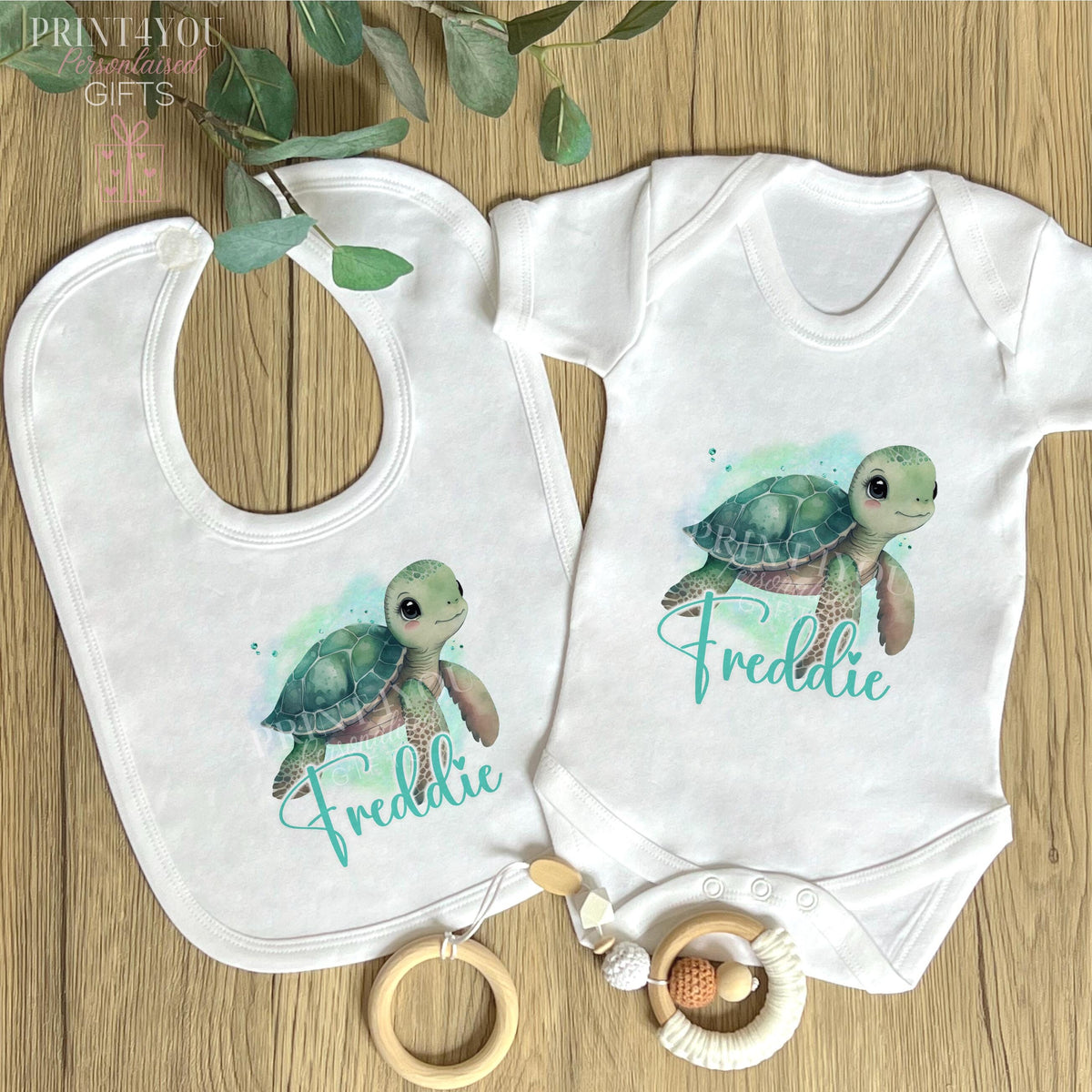Close-up of the cute sea turtle print on the personalised newborn vest.