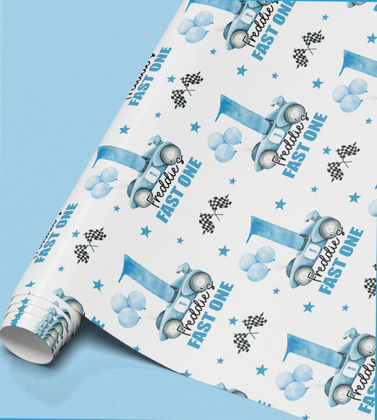 a roll of wrapping paper with a repeating pattern of blue balloons, racing cars, and stars.