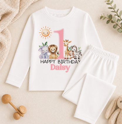 A white long-sleeved shirt with a graphic design featuring a sun, animals, and the text "Happy Birthday Daisy" printed on it, along with a pink number 1.