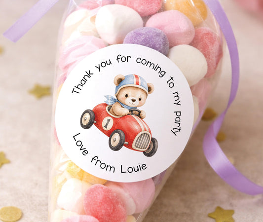 Personalised glossy round sticker featuring a teddy bear driving a racing car