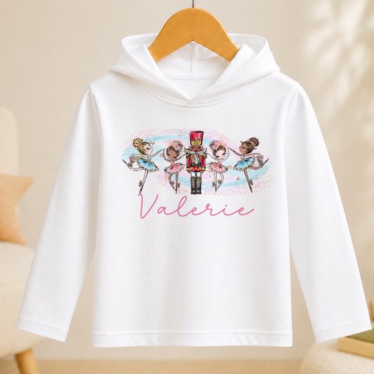 A white hoodie with a printed design of ballet dancers and a nutcracker figure, along with the name "Valerie" written on the front.