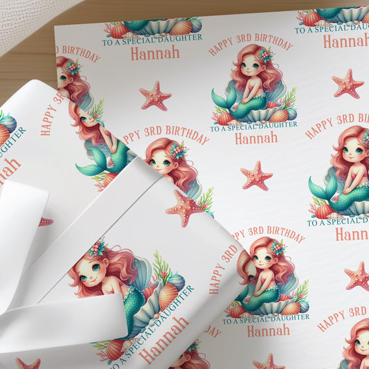 Close-up of personalised mermaid birthday wrapping paper with a repeating pastel mermaid, seashell and starfish pattern on premium white gift wrap.