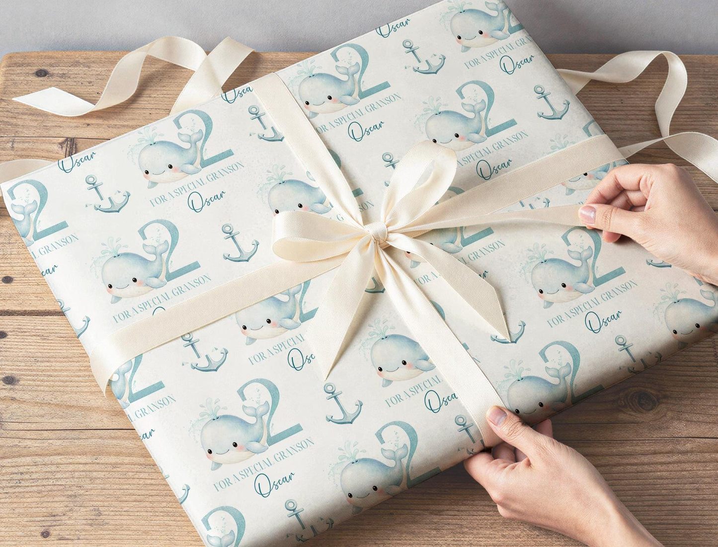 Close-up of the pastel blue whale and anchor pattern on the personalised wrapping paper.
