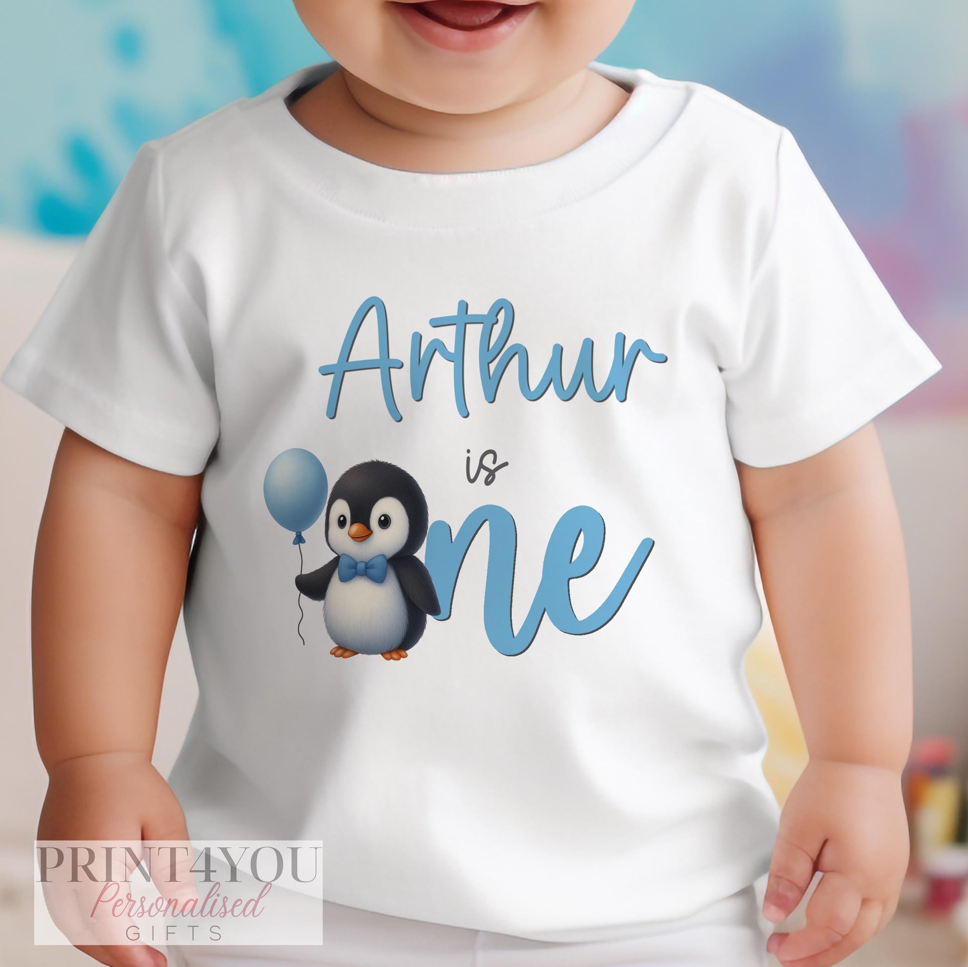 Personalised blue penguin first birthday vest with custom name printed on soft cotton