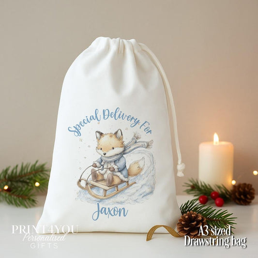 Personalised fox Christmas sack, white A3 drawstring gift bag printed with a fox in a blue coat on a sleigh and Special Delivery For a name