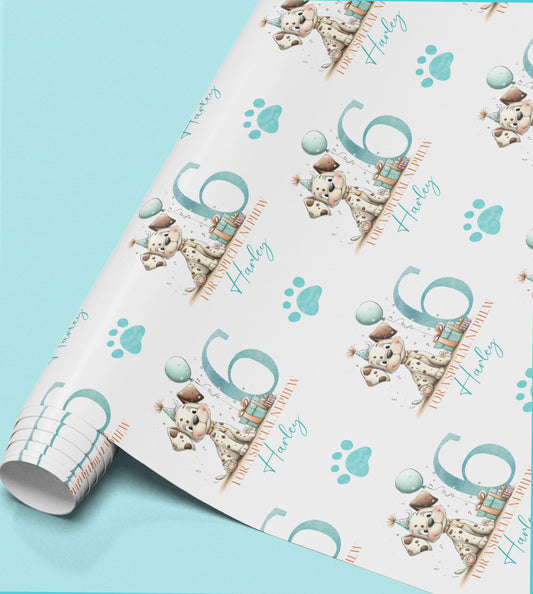 Roll of personalised puppy birthday wrapping paper with a dog wearing a party hat, paw prints and a custom age.