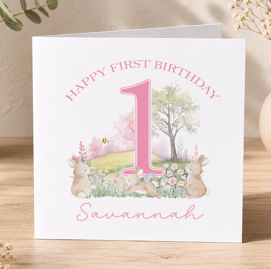 Square first birthday card for Savannah featuring pink illustrated rabbits and flowers around a bold pink number one.