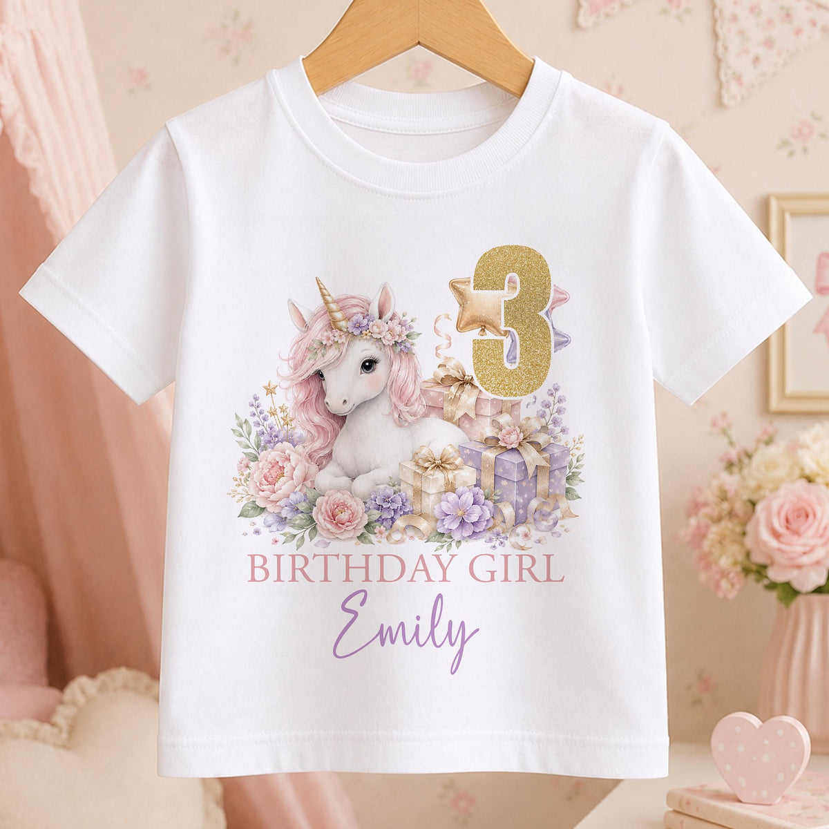 White cotton t-shirt printed with a floral unicorn, roses and gifts beside a gold glitter age number, with Birthday Girl and a name below.