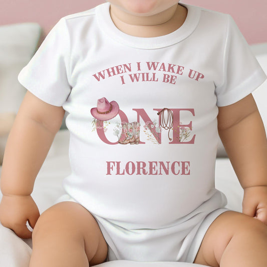 Personalised pink cowgirl first rodeo bib, printed with your baby's name and western cactus design.