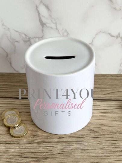 Close-up of the fluffy watercolour Highland cow design and autumn leaf details on the personalised ceramic money box