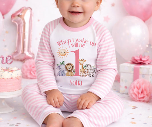 Personalised pink safari first birthday outfit with elephant, lion, giraffe and zebra design and custom name.