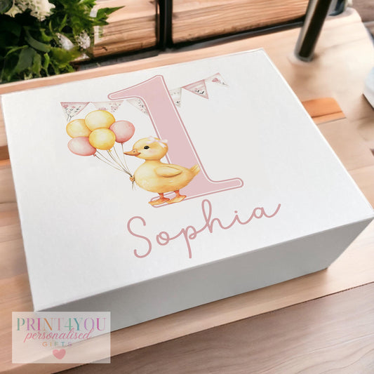 White magnetic-close keepsake box for a baby's first birthday, personalised with the child's name and printed with a pink duck and balloons design, shown in the medium 160 x 200 x 80mm size
