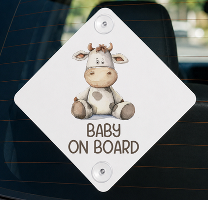 a sticker with a cartoon cow and the text "BABY ON BOARD" printed on it.