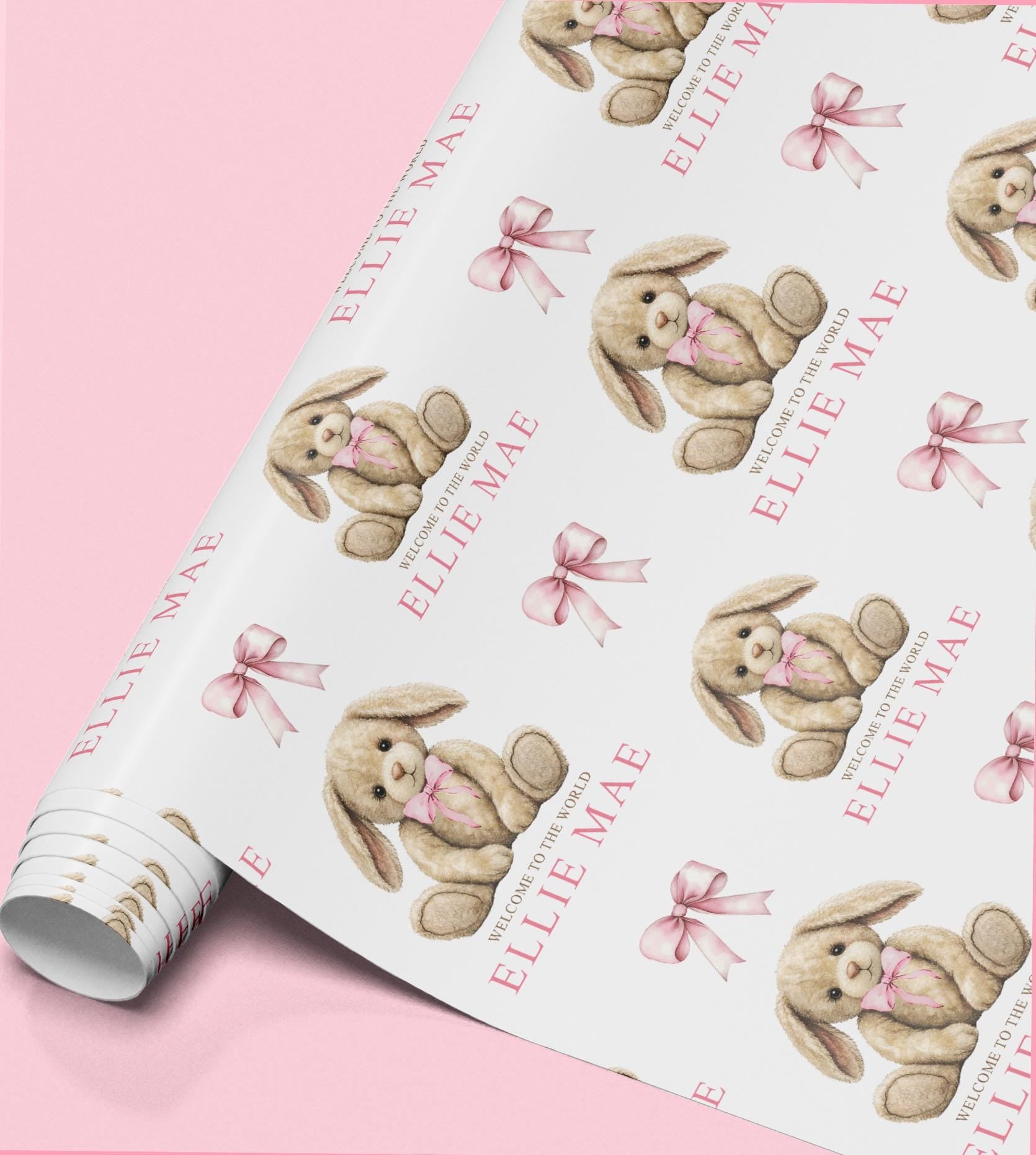 Roll of personalised newborn gift wrap with a repeating bunny teddy design in soft pink, personalised with the name 'Ellie Mae'.