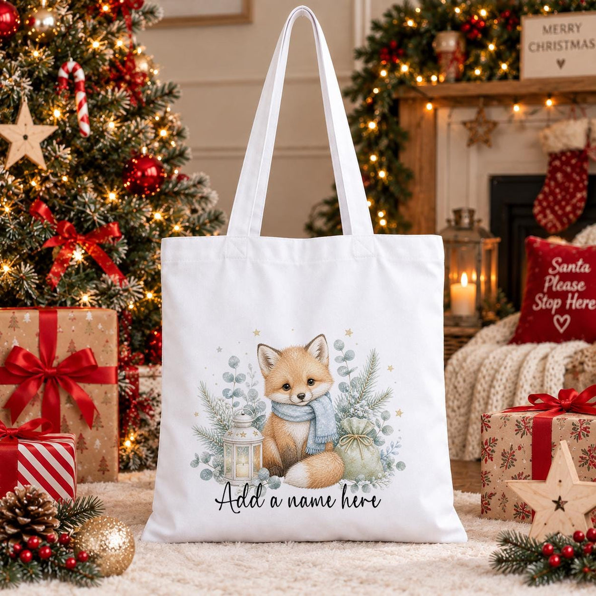 White cotton tote bag printed with a fox cub in a blue scarf beside a lantern, gift sack and eucalyptus, above a name in script.