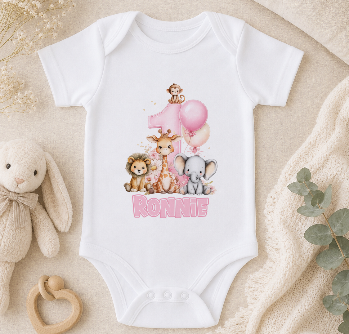 White baby onesie personalised with a pink number one, giraffe, lion and elephant illustrations and the sample name 'Ronnie'