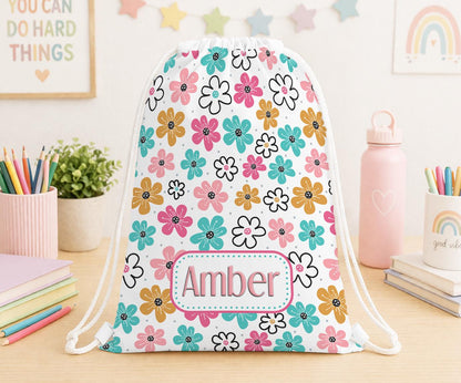 Drawstring PE bag printed with a daisy flower design, personalised with a child's name across the front