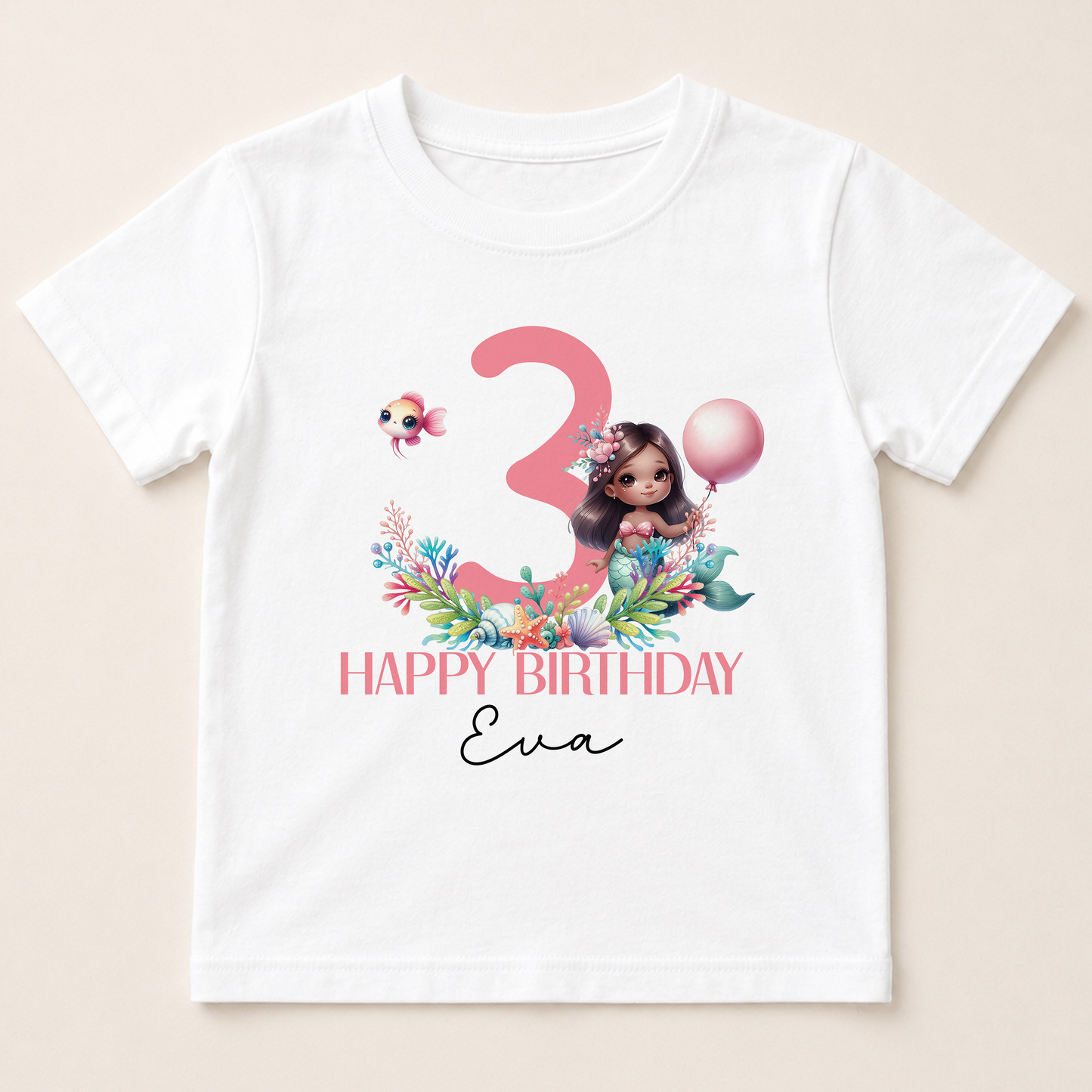 A white t-shirt with a graphic design featuring a mermaid character, a number 3, and a balloon. The text below the design reads "Happy Birthday Eva".
